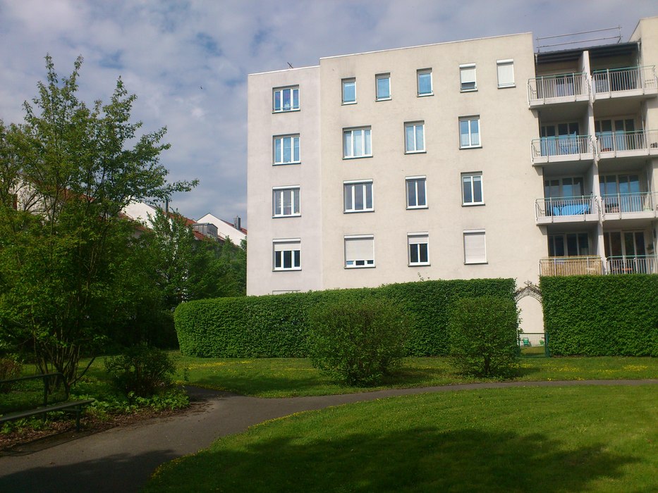 Aussenansicht des Gebäudes der 2 Zimmerwohnung mit schönen Grünfllächen im Vordergurnd