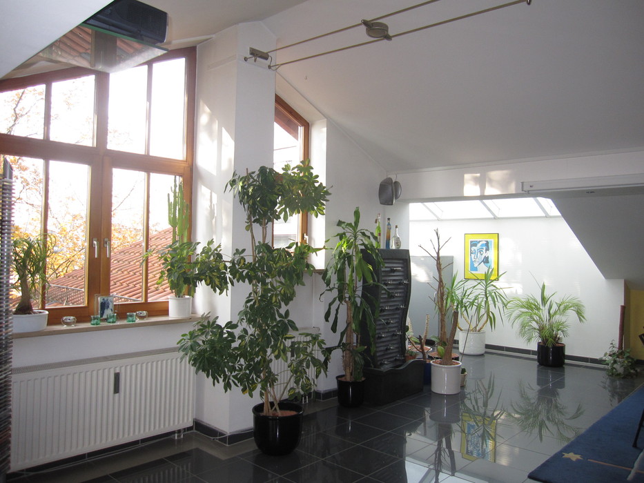 Wohnzimmer_Wintergarten helles Wohnzimmer und Wintergtarten, gefliest, mit vielen Grünpflanzen,