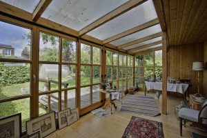 Heller Wintergarten mit Holzfensterfronten mit Holzkreuz