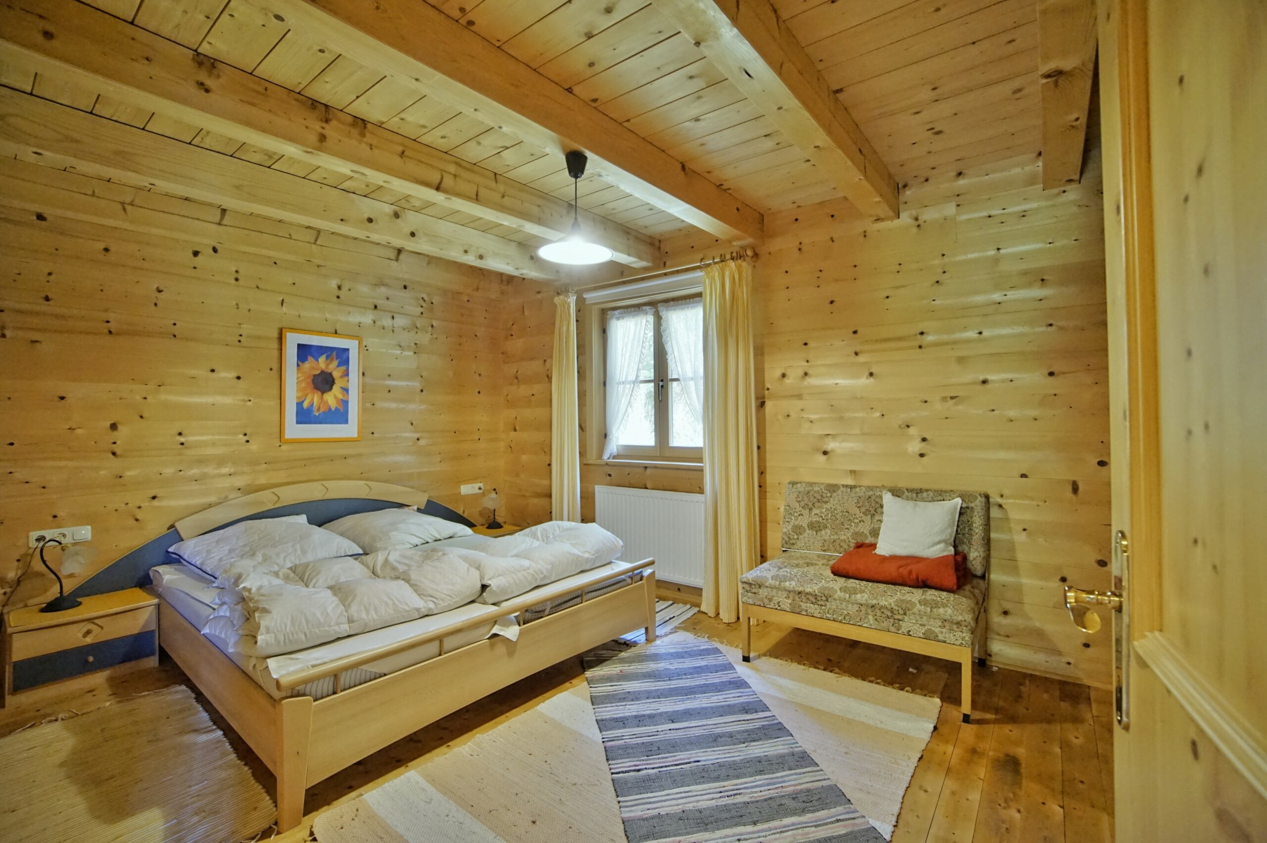 Schlafzimmer mit Doppelbett und viel Holz