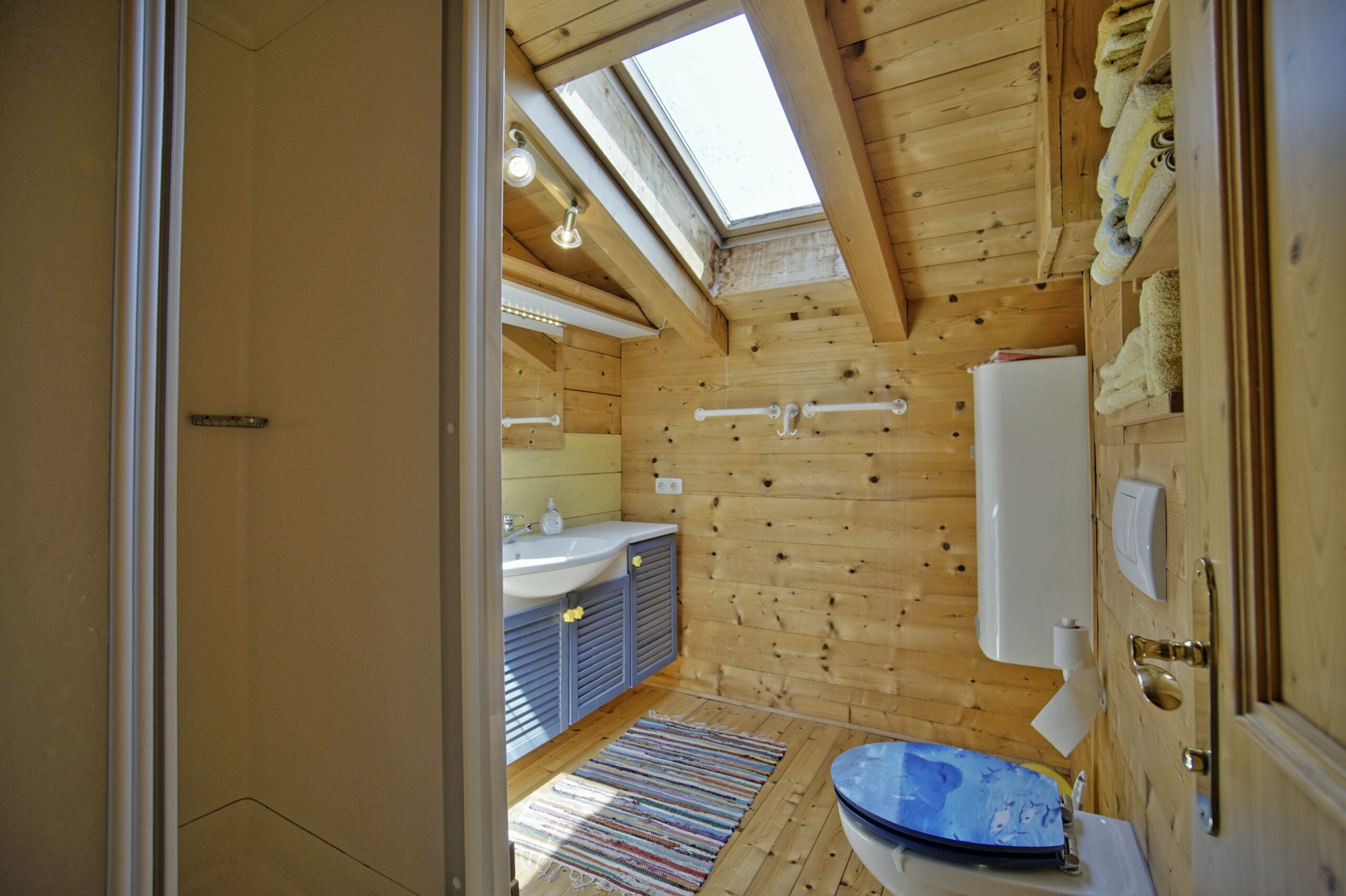 Badezimmer mit viel Holz und Dachfenster
