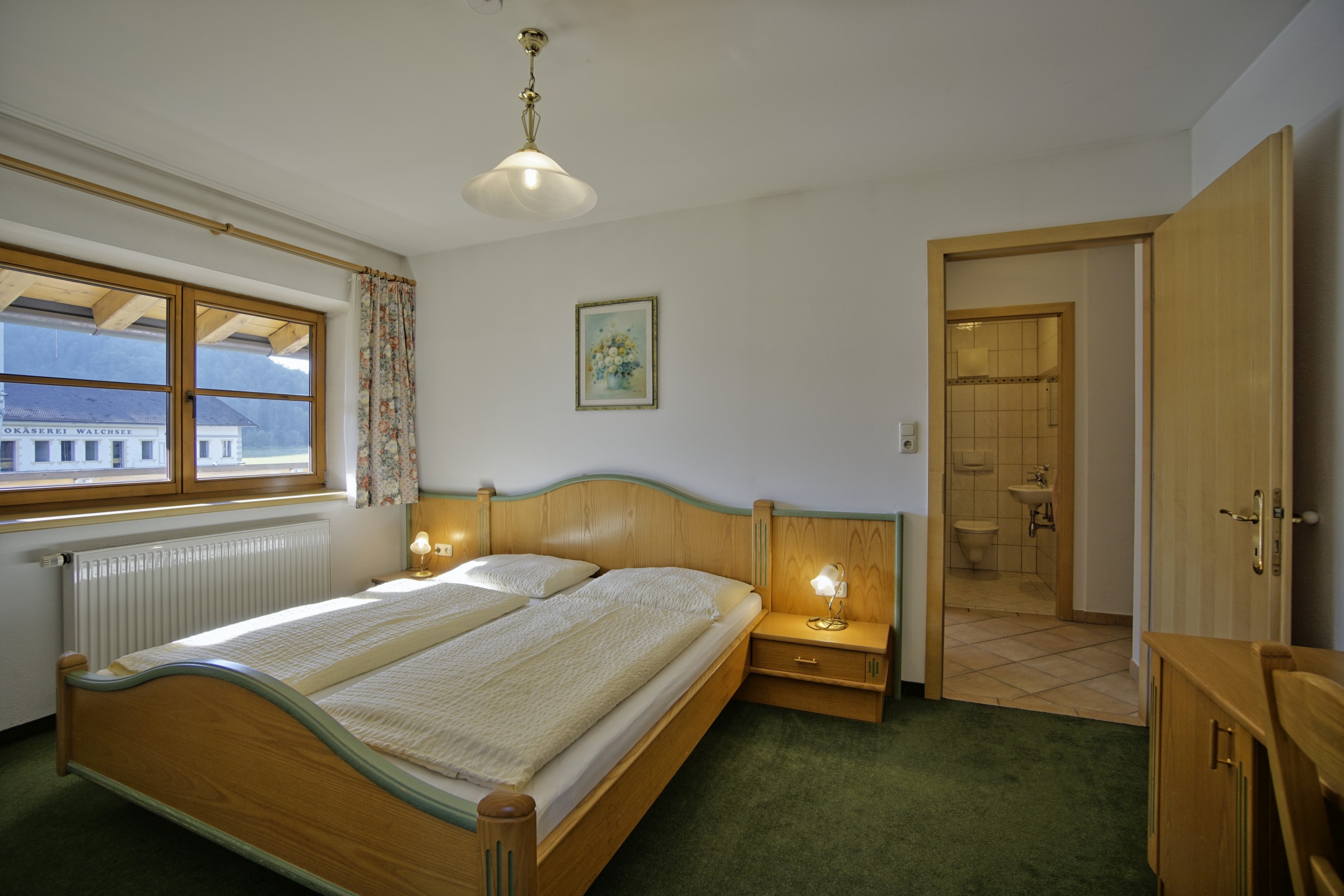 Schlafzimmer mit Doppelbett und Teppichboden