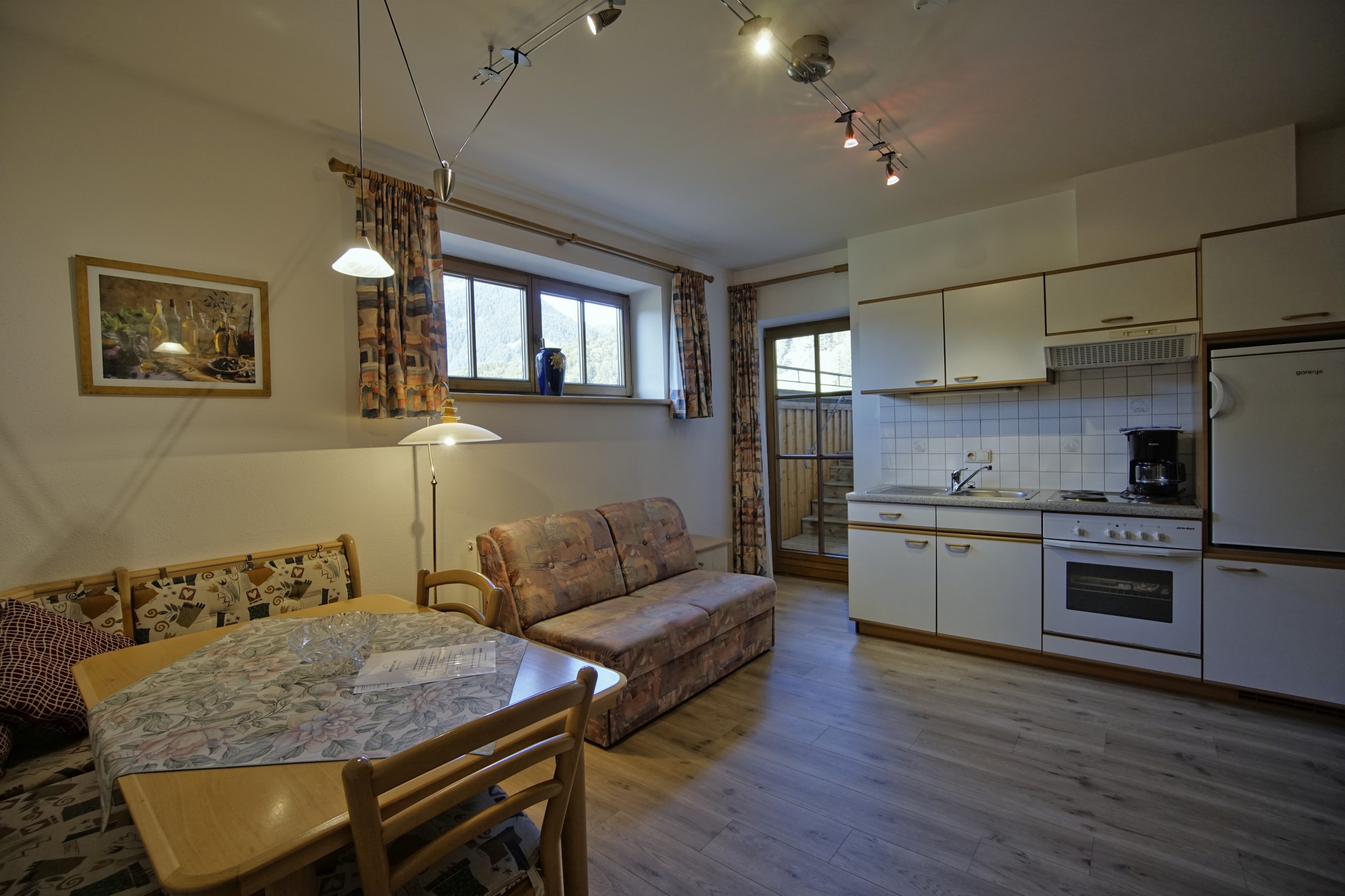 Küche mit Holzboden und Tür zur Terrasse, Sitzecke